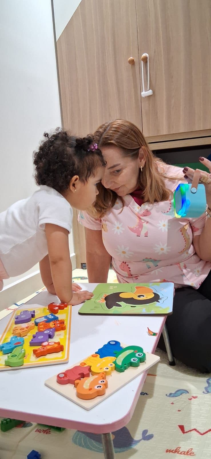 Sessão com a fonoaudióloga e criança usando quebra-cabeça